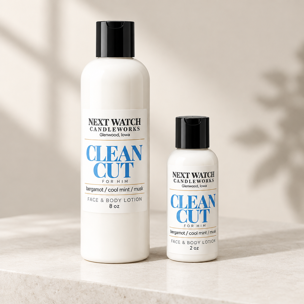 Two white bottles of Next Watch Candleworks Clean Cut For Him face and body lotion, one 8 oz and one 2 oz, standing on a light marble surface with soft shadow overlays.
