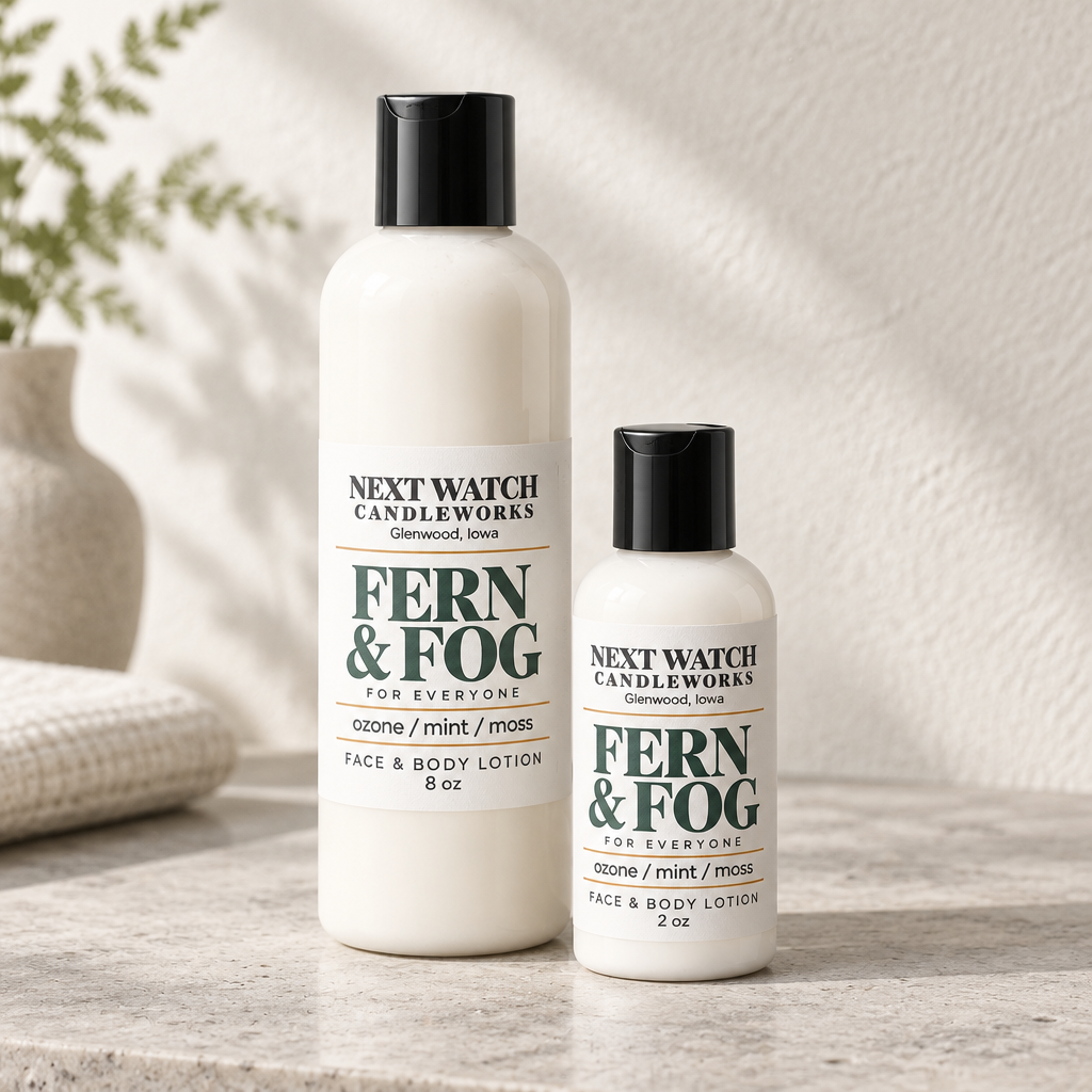 Two bottles of Next Watch Candleworks Fern & Fog Face & Body Lotion, one 8 oz and one 2 oz, standing on a light stone surface with a neutral textured background.